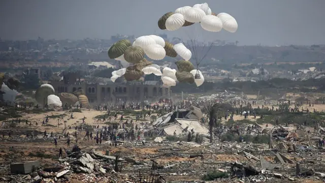 Uma multidão em meio à Gaza destruída e cheia de escombros