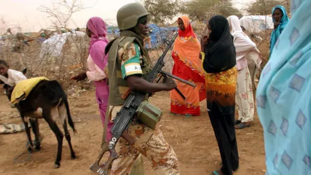 Seorang tentara Uni Afrika (AU) Rwanda berpatroli pada 4 Juni 2005 di kamp pengungsi internal [IDP] Zam Zam, 25 km dari El Fasher di Darfur utara selama kunjungan Komisaris Perdamaian dan Keamanan Uni Afrika Said Djinnit. 30.000 orang tinggal di kamp pengungsi internal ini, yang secara rutin menjadi korban pelanggaran yang dilakukan oleh tentara Sudan atau pemberontak.