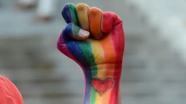 Un puño pintado con los colores de la bandera LTBG