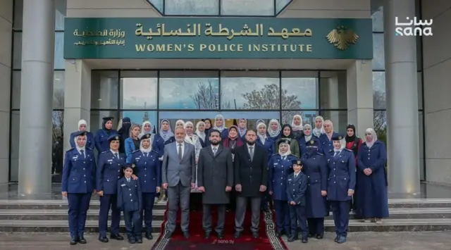 تظهر الصورة الجماعية التي ضمّت وزير الداخلية في الحكومة الانتقالية السورية برفقة إدارة معهد الشرطة النسائية، نحو 29 امرأة من الإداريات والضابطات؛ بدت واحدة منهن فقط من دون غطاء رأس، بينما ترتدي اثنتان النقاب، في حين ظهرت باقي المشاركات بالحجاب.