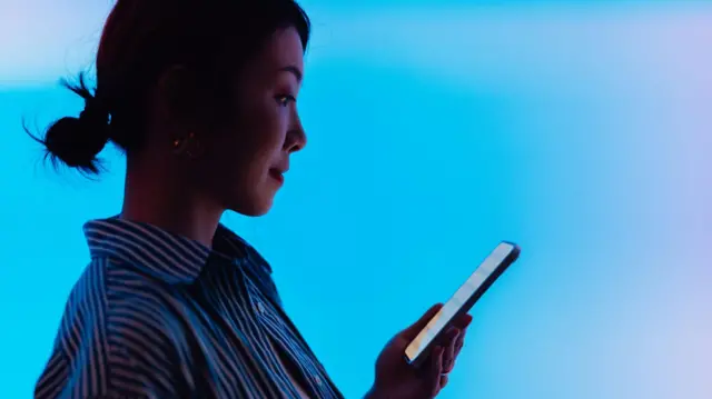 स्मार्टफोन हाताळणारी तरुणी