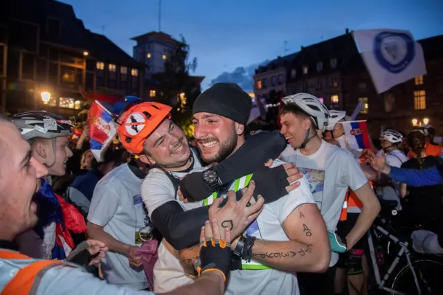 Dvojica biciklista se grle i plaču