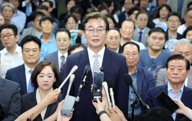 여러 대의 마이크 앞에 서서 소감을 말하는 전재수 후보