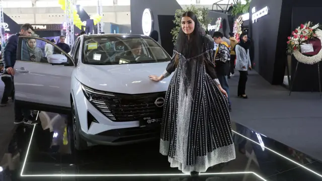 یک مدل ایرانی در نمایشگاه خودرو تهران ۲۰۲۵ در مجتمع نمایشگاهی شهر آفتاب، جنوب تهران، ایران، ۳۰ ژانویه ۲۰۲۵، در کنار یک خودرو ژست گرفته است. به گزارش خبرگزاری ایرنا، ۴۴ شرکت داخلی و خارجی در این نمایشگاه که تا ۳۱ ژانویه ۲۰۲۵ ادامه دارد، شرکت می‌کنند. نمایشگاه خودرو تهران ۲۰۲۵، ایران