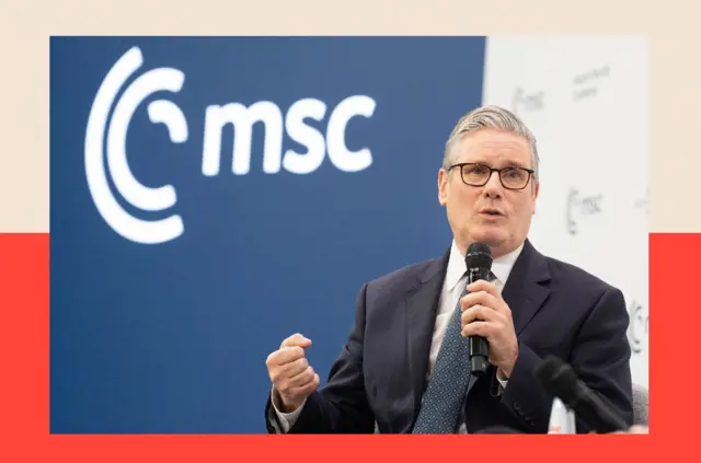 Kir Starmer u tamnom odelu, plavoj kravati i sa mikrofonom u levoj ruci na konferenciji u Minhenu