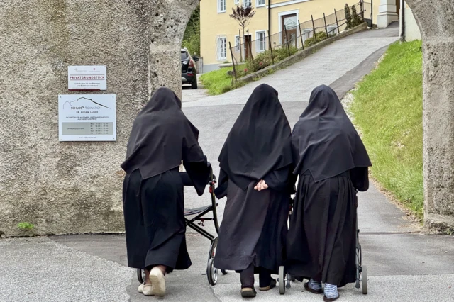Las monjas caminando de espaldas de regreso al convento.
