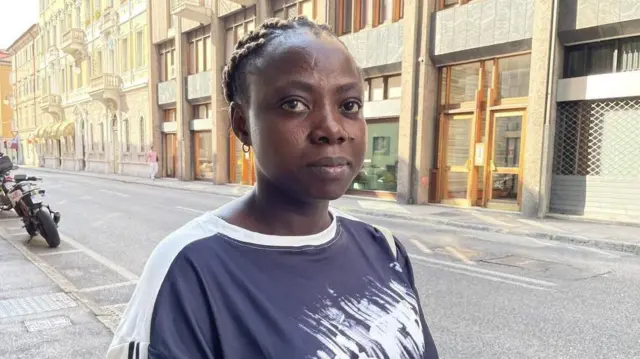 امرأة تقف في الشارع وتنظر إلى الكاميرا