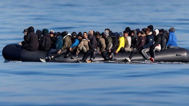 Un grupo de inmigrantes en un bote en el mar