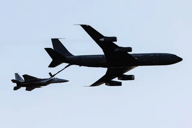 An Israeli KC-135 Stratotanker Boeing 707 plane refuels an F-15 fighter jet as they take part in an air show for a graduation ceremony at the Hatzerim base in the Negev desert, near the southern Israeli city of Beersheva, on December 31, 2015