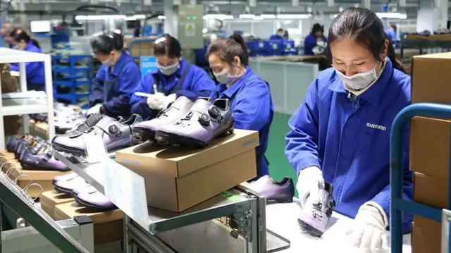 Trabajadores procesan calzado para la exportación en un taller de una empresa en Lianyungang, provincia de Jiangsu, China, el 16 de diciembre de 2025.
