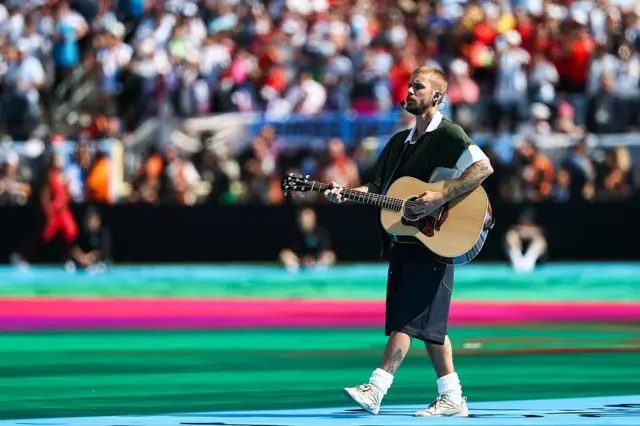 Justin Bieber elinde gitar tutuyor.