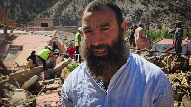 Marzouk se tient devant les sauveteurs à la recherche de restes humains.