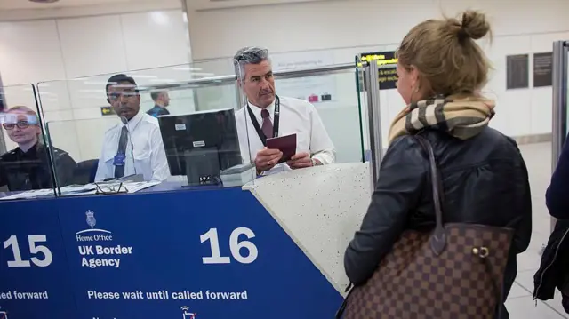 Straż Graniczna (Border Force) sprawdza paszporty pasażerów przylatujących na lotnisko Gatwick w Londynie w Anglii