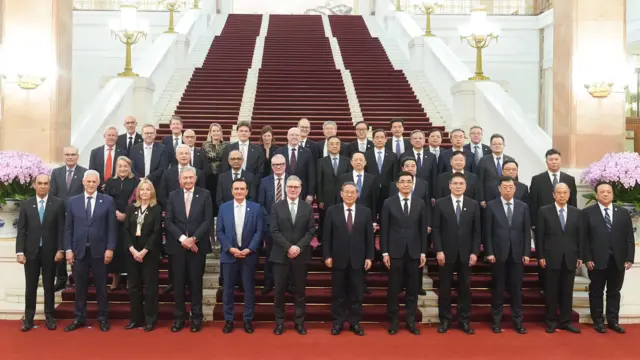 施紀賢爵士（中左）與李強（中右）在北京人民大會堂樓梯前與出席中英企業家委員會會議的企業代表合照（中新社圖片29/1/2026）