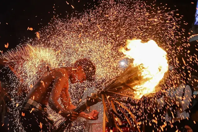 BALI, INDONESIA - 18 MARET: Warga Bali saling memukul dengan daun kelapa kering yang terbakar selama ritual api menjelang hari suci Nyepi, Hari Raya Keheningan Bali, di Desa Paksebali, Klungkung, Bali, Indonesia pada 18 Maret 2026. Ritual yang dikenal secara lokal sebagai Lukat Geni ini diyakini sebagai bagian dari penyucian menggunakan api untuk membakar semua energi negatif dan untuk menyelaraskan alam semesta. Warga Bali akan merayakan Nyepi pada 19 Maret 2026, di mana umat Hindu di pulau Bali tidak diperbolehkan bepergian, bekerja, menyalakan lampu, memasak, atau melakukan aktivitas lainnya. (Foto oleh 