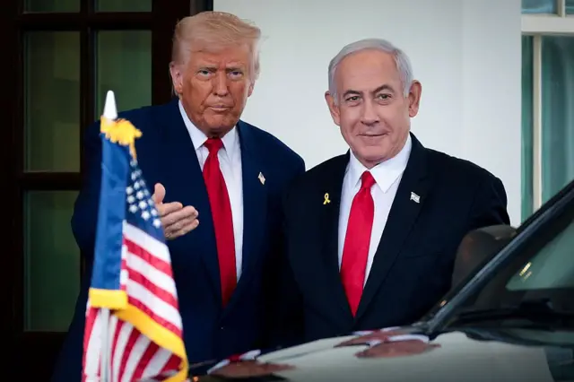 الرئيس الأمريكي دونالد ترامب ورئيس الوزراء الإسرائيلي بنيامين نتنياهو يقفان إلى بعضهما البعض وأمامها العلم الأمريكي في البيت الأبيض في 7 أبريل/نيسان عام 2025.