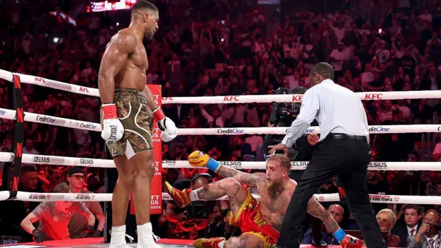 Anthony Joshua stands over Jake Paul on the canvas