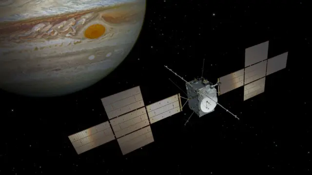 طرحی از کاوشگر اکتشافی قمرهای یخی مشتری (Juice) متعلق به آژانس فضایی اروپا، با ابزارها و آنتن‌ها در بخش میانی، در حالی که دو «بال» از صفحات خورشیدی در دو طرف آن قرار دارند؛ فضاپیما در فضای بیکران در حال پرواز است و سیاره مشتری در پس‌زمینه دیده می‌شود
