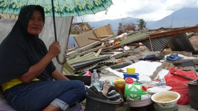 Hasnah, penyintas gempa Palu mengumpulkan barang-barang yang masih bisa diselamatkan dari bekas rumahnya di Petobo.