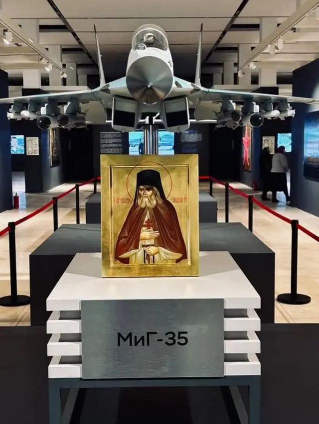 Икона на фоне макета истребителя