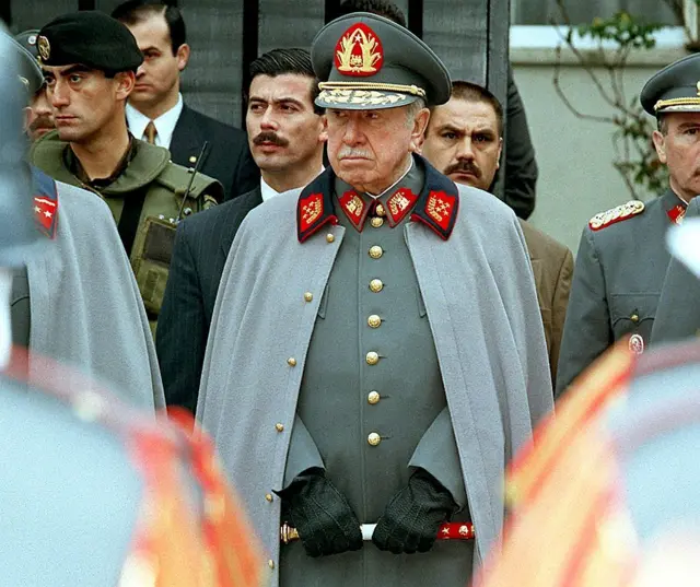Un retrato del general Augusto Pinochet en 1997, vestido de uniforme militar y con capa.