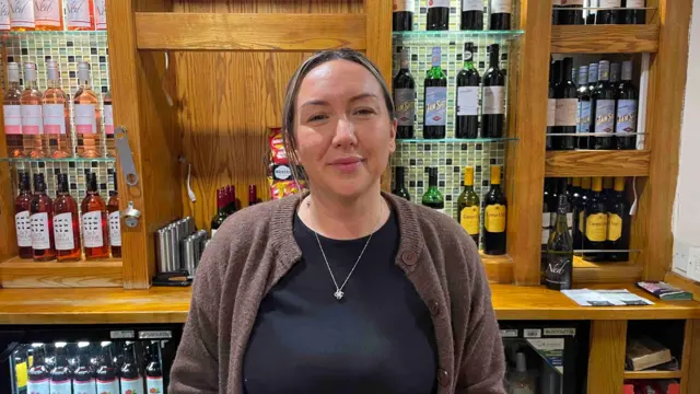 Lindsay Tinsley, quien dijo que estaba triste porque el cine ya no estaba abierto, aparece en la foto detrás de la barra de un pub, con botellas de vino visibles en el fondo.