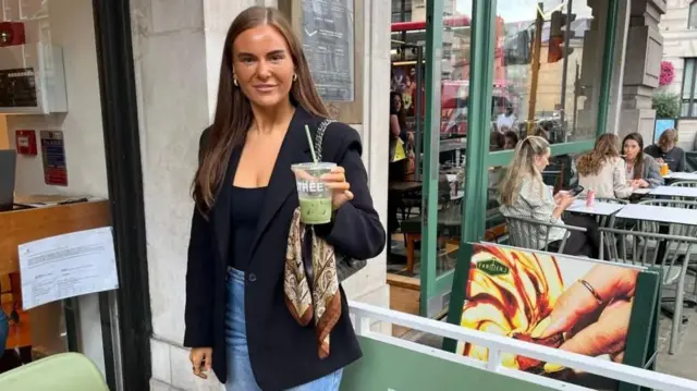 لوسي ويليامز تحمل كوبا من مشروب الماتشا المثلج في مقهى بلانك ستريت
