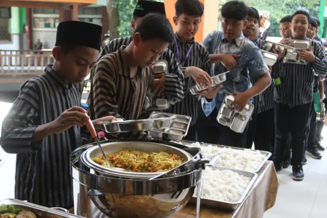 Siswa antre mengambil makanan secara prasmanan dalam uji coba pelaksanaan program Makan Bergizi Gratis (MBG) di MIN 2 Kota Malang, Jawa Timur, Kamis (02/04).