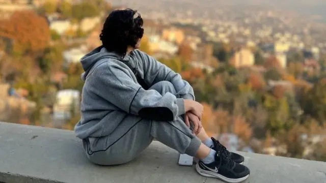 दीवार पर बैठी हुई एक महिला