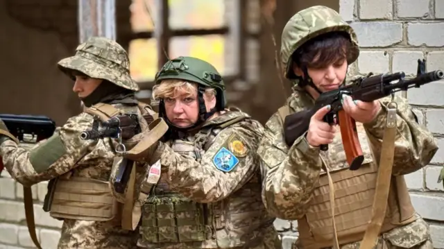 迷彩服に身を包み、ライフルを構えるウクライナの3人の女性