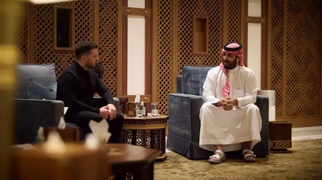 Ліворуч у кріслі сидить президент України Зеленський, праворуч - коронний принц, прем'єр Саудівської Аравії Мухаммад бін Салман. 