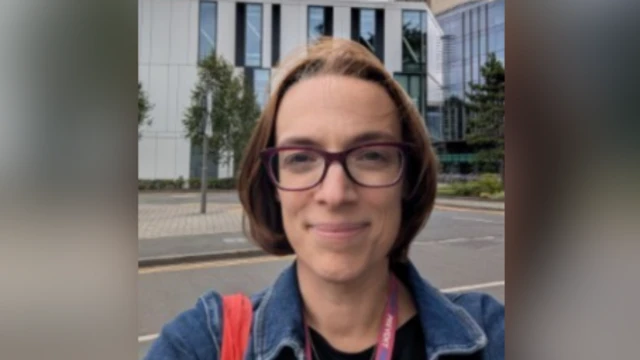 Dra. Harrison. Una mujer de cabello castaño y gafas se toma una selfi. Al fondo se ve una carretera.