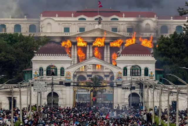 El fuego y el humo se elevan desde el palacio Singha Durbar, que alberga los edificios del gobierno y el parlamento, después de que los manifestantes irrumpieran en las instalaciones durante violentas manifestaciones en Katmandú, Nepal, el 9 de septiembre de 2025.