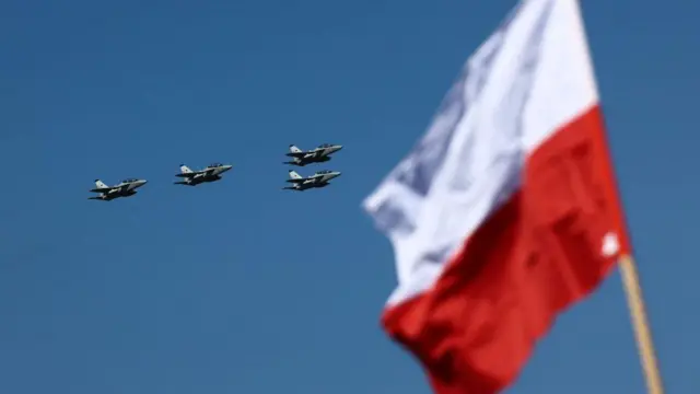 Samoloty widoczne podczas parady z okazji Dnia Sił Zbrojnych w Warszawie, z prawej strony powiewa biało-czerwona flaga