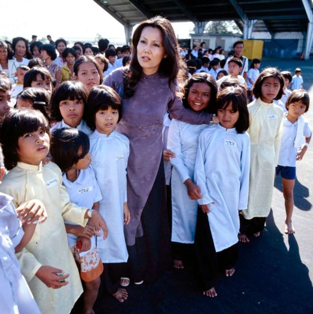 Nghệ sĩ Kiều Chinh cùng các em bé mặc áo dài trong phim The Children of An Lac của đài CBS vào năm 1980, phim quay ở Philippines