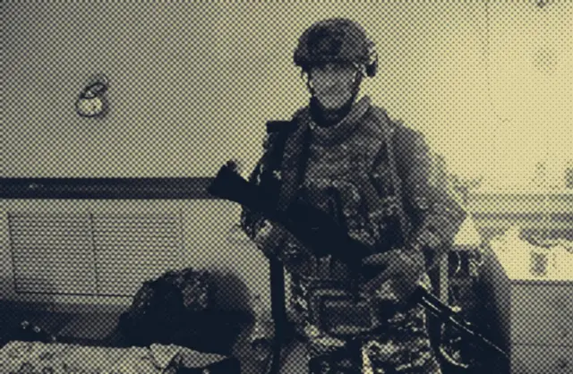 Денис Соболев в военной экипировке с автоматом