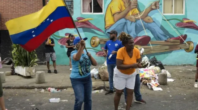 Une femme brandit le drapeau vénézuelien