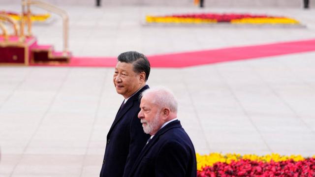 Luiz Inacio Lula da Silva e Xi Jinping caminhandoroleta de números de 1 a 6pátio durante cerimônia