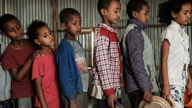 Des enfants faisant la queue pour se nourrir.