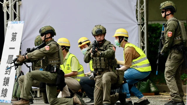 Ratownicy i wolontariusze zabezpieczają obiekt telekomunikacyjny podczas ćwiczeń odporności miejskiej po ćwiczeniach przeciwlotniczych, będących częścią corocznych ćwiczeń wojskowych Han Kuang w Tajpej na Tajwanie