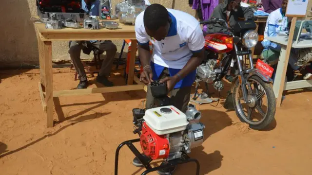 A rehabilitated boko haram ex-fighter showing how to operating a vulcanising machine