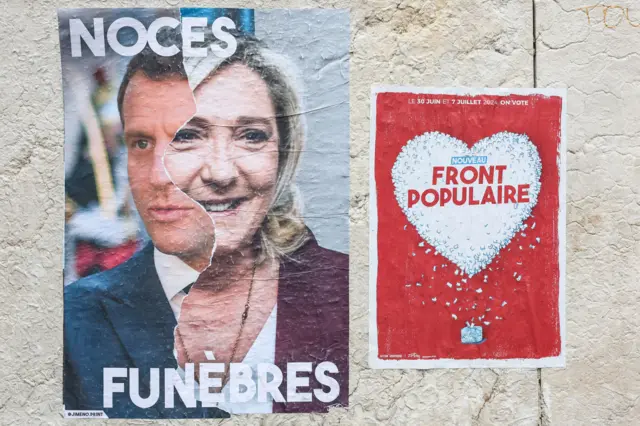 Um cartaz com uma fotografia do presidente francês Emmanuel Macron (esquerda) e Marine Le Pen (direita), diz 'casamento fúnebre', ao lado de um adesivo da 'Nova Frente Popular'.