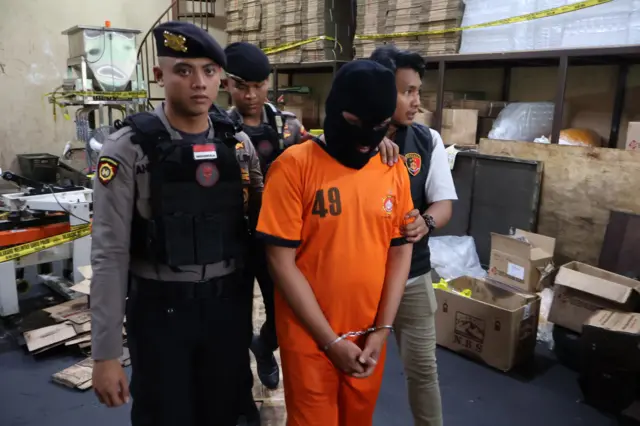Polisi menggiring tersangka kasus pemalusuan minyak goreng dengan merek dagang Minyakita, TRM (tengah) saat rilis di Sukaraja, Kabupaten Bogor, Jawa Barat, Senin (10/3).