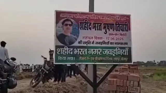 जवइनियां गाँव में भरत भूषण की स्मृति में एक होर्डिंग लगाया गया है 