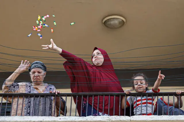 سيدة تلقي الحلوى خلال مرور موكب الاحتفال بالمولد النبوي في القاهرة 27 سبتمبر/أيلول 2023