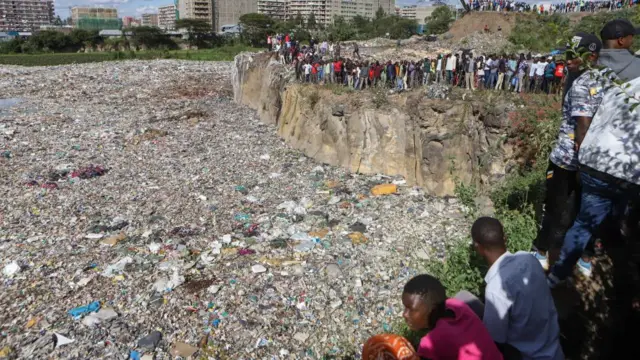 Foule de personnes regardant une immense décharge à Nairobi