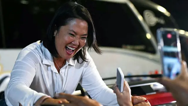 Keiko Fujimori, saluda a sus seguidores durante un mitin de campaña en Huacho, al norte de Lima, Perú, el 2 de junio de 2026. Lleva una camisa blanca y sonríe mientras agarra las manos de varias personas que están allí para saludarla.