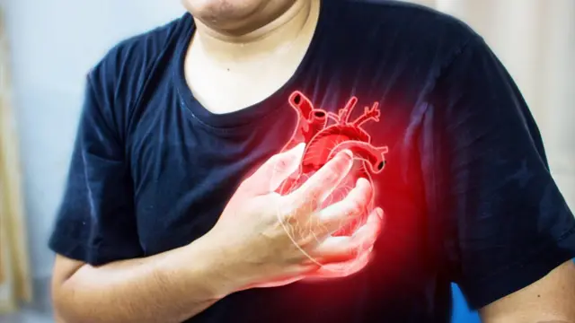 رجل يمسك صدره من الألم الحاد.