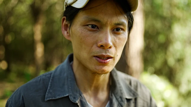 Silva Gu in a white cap and grey shirt speaks as he faces the camera.