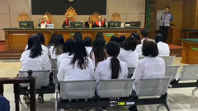 Para terdakwa duduk di kursi di depan hakim